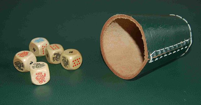 A set of poker dice and a dice cup