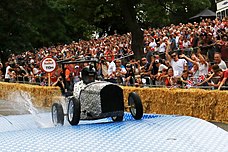 Um participante dirigindo pelo curso da Red Bull Soapbox Race realizada em Alexandra Palace, Londres em 2017.