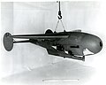 The "Pelican" was developed concurrently with the "Bat" by NBS, the Navy Bureau of Ordnance, and the MIT Radiation Laboratory. The "Pelican" is shown with instrumentation for field testing. Directly beneath the wing, shown in the photo, was mounted a 16mm Bell and Howell Type M-4A gun sight aiming point camera. Slightly forward and lower was mounted a 16mm Cine Kodak Model E camera. The housing on the nose covered a panel of signal lamps indicating the application of radar controls. The cameras simultaneously photographed the panel and the ground ahead of the glider.