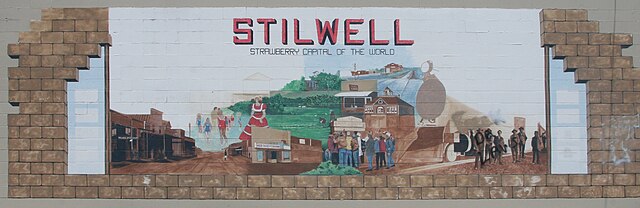 Mural depicting Stilwell on the exterior of a payday loan business. It is now obscured by an abandoned restaurant.