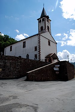 Igreja de Urepel;  a seus pés, uma placa indica o país Quint