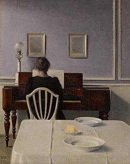 Interieur met vrouw achter de piano