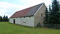 Three-sided courtyard with residential stable, two barns, courtyard wall with gate pillars and the sandstone retaining wall along the road