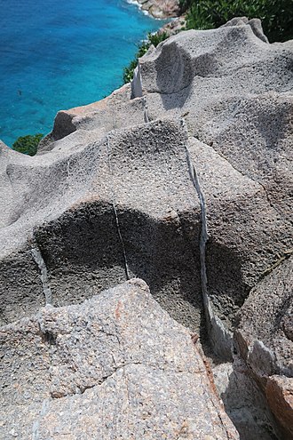 Granite rock in the cliff of Gros la Tete - Aride Island. The thin (1-3 cms. wide) brighter layers are quartz veins, formed during the late stages of crystallization of granitic magmas. They are also sometimes called "hydrothermal veins" ArideGranite1.jpg