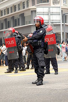 A member of the Federal Reserve Unit prepares to disperse the protesters with tear gas. Bersih FRU police.jpg