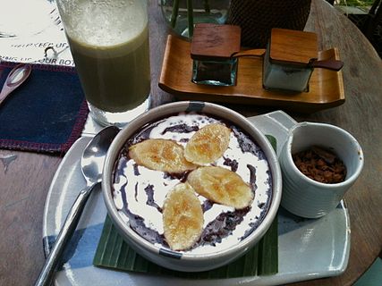 Bubur ketan hitam served with thick coconut milk and sliced baked banana.