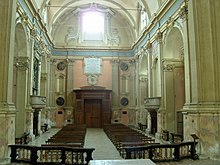 Fotografía en color de la nave barroca de una iglesia, vista hacia la fachada.