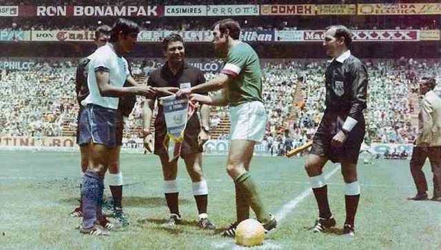 Salvadoran captain Salvador Mariona (in white) and Mexican captain Gustavo Peña (in green) before their match.