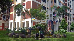 A stone with 'Gek Poh Ville' carved on it in Singapore's official languages