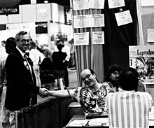 BMUG technical manager Steve Costa shakes hands with BMUG member and MacUser editor Gil Davis. MacWorld Expo San Francisco 1989. Herb Dang in the background. Gil-Davis-Steve-Costa-Herb-Dang.jpg