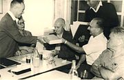 Harry e David estão recebendo livros de escritos de Ber Borochov da Histadrut. Ida os observa, 10 de novembro de 1964