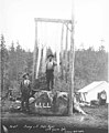 Loggers with assortment of saws standing on stump which reads LLLL (for Loyal Legion of Loggers and Lumbermen) and below sign (KINSEY 762).jpeg