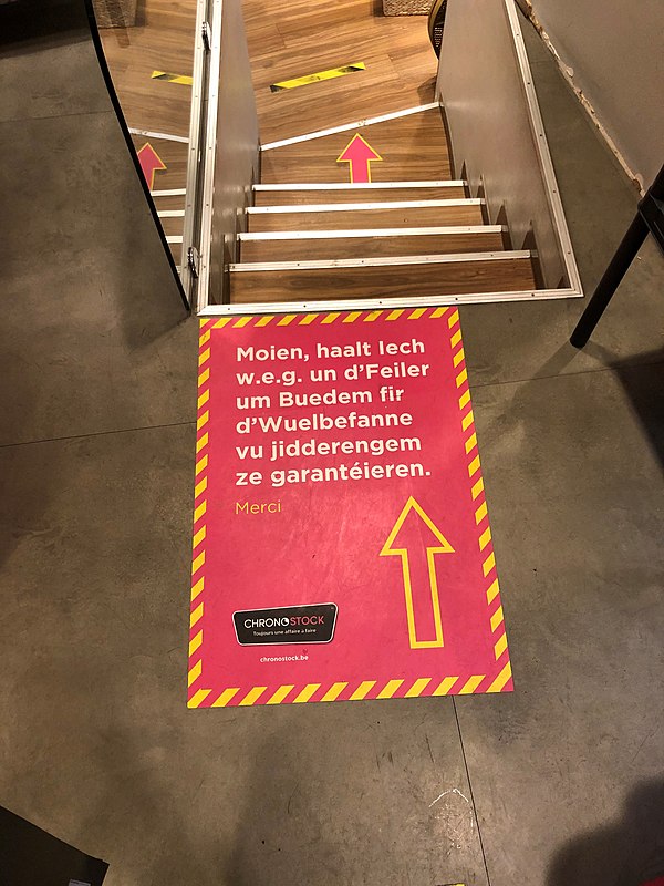 Sign in Luxembourgish indicating the way to walk through a shop during the COVID-19 pandemic