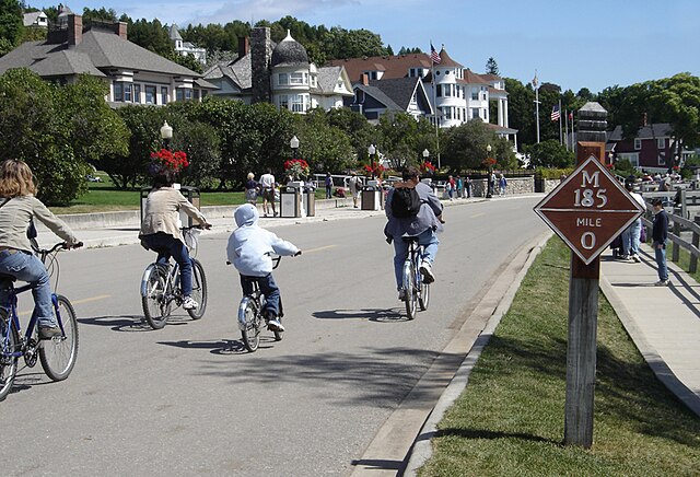 Bikers on M-185 at mile marker 0 in downtown Mackinac Island