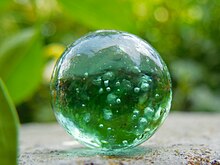 A green glass marble in India Marble (toy).jpg