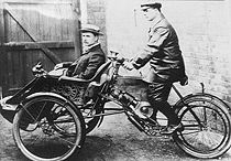 Een Wearwell "Motette" tricycle uit 1903 met Fred Adey als rijder en Harry Stevens als passagier.