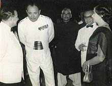 Ayub Khan en uniforme blanc entouré de trois hommes en tenue de soirée et d'une femme de profil en sari