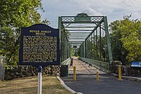The Nevius Street Bridge was completed in 1886 by the Wrought Iron Bridge Company, it is still utilized by pedestrians crossing the river today Nevius Bridge Raritan NJ 2.jpg