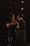 A man and a woman dressed in black performing on a stage.