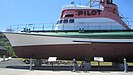 Vorderer Teil des auf dem Festland stehenden Museumschiffs, es zeigt die große Aufschrift „PILOT“ auf der turmartigen Kommandobrücke.
