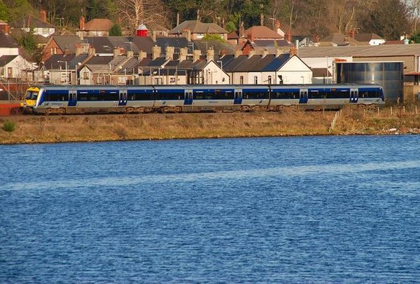 A C3K train running on the Larne Line alongside Larne Lough heading towards Larne Harbour.