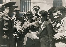 Tunisian Jews tear off the yellow badge from their clothes, encouraged by the Allied soldiers who liberated their village from Vichy French rule Removing yellow badge.jpg