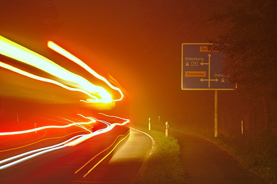 Light trail of a bus on a foggy evening in Sandkrug, Germany.