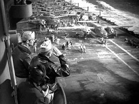 The B-25s about to launch from USS Hornet. Admiral Halsey (Morris Ankrum) is saluting in the foreground. Thirty-seconds-over-tokyo.jpg