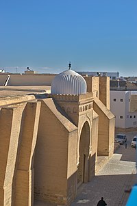 Photographie du porche de Bab al-Gharbi et de sa coupole côtelée. Sa calotte blanche est ornée extérieurement de cinquante-trois côtes saillantes. Le porche de Bab al-Gharbi est le premier porche depuis l'extrémité sud de la façade occidentale.