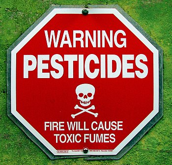 English: A sign warning about pesticide exposure.