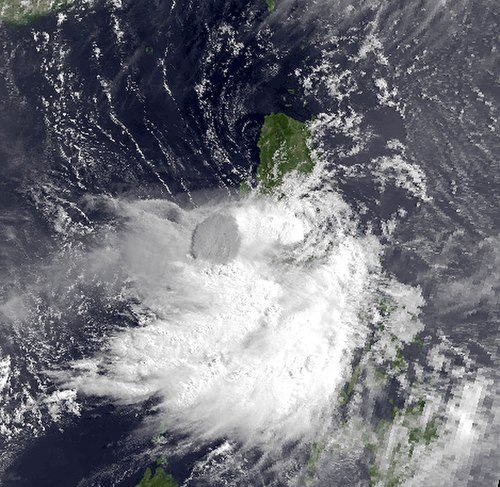 Satellite image of Yunya as it made landfall; the eruption column from Mount Pinatubo (in dark grey) can clearly be seen through the storm's clouds