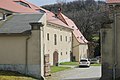 Südöstliches Wohnhaus über winkligem Grundriss mit angebautem Seitengebäude, nördliches Seitengebäude und westliche Scheune sowie nördliche Toreinfahrt mit zwei Torpfeilern, zwei Granittröge und Einfriedungsmauer an der Hauptstraße (Erbrichtergut)