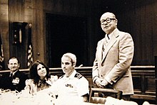 Carol McCain (left center) and John McCain (right center) at a May 1973 appearance on Capitol Hill in Washington in honor of returned POWs. The person speaking is Senator Carl Curtis from Nebraska. 428-GX-USN 1156097 (26392700520).jpg