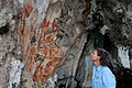 A tourist looks are rock art in West Papua, Bird's Head Seascape.jpg