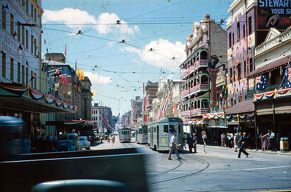 Trams and buildings in Adelaide Street decorated for the visit of Queen Elizabeth II in 1954