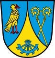 Markt Prien a.Chiemsee In Blau eine eingeschweifte goldene Spitze, darin ein unterhalbes zerbrochenes blaues Rad; vorne ein linksgewendeter, rot bewehrter goldener Falke, hinten zwei wachsende, schräg gekreuzte goldene Abtstäbe mit abgewendeten Krümmen.