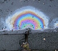 Iridescence de carburant diesel sur une route mouillée