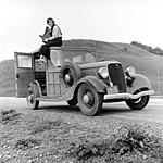 Dorothea Lange på sin bil, en Ford Model 40 stationsvagn, 1936. Kameran är en Graflex. Fotot är taget av Rondal Partridge.