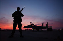 SSgt Nasam Rissvi guards an F-15 at Otis ANGB during a December sunset F-15C Guard, Otis.jpg