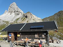 Vue du Filmoor-Standschützenhütte, un refuge de montagne, dominé par le sommet.