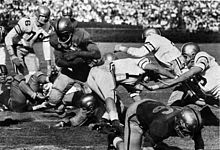 In 1956, Pitt's Bobby Grier (pictured carrying the ball) was the first to break the Sugar Bowl's color-barrier GreirSugarBwolpg322 1956OWL.jpg