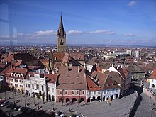 Ein Platz mit mittelalterlichen Gebäuden und einem Turm