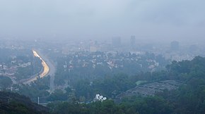 Photographie du centre-ville de Los Angeles vu depuis des collines éloignées.