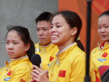 Photo de Huang Shanshan en tenue de l'équipe de Chine tenant un micro à deux mains