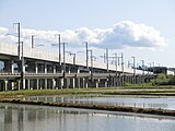 地上側から見た北海道新幹線と在来線との分岐点、左側から右側にかけて斜めに上がる高架橋が在来線用のスロープ
