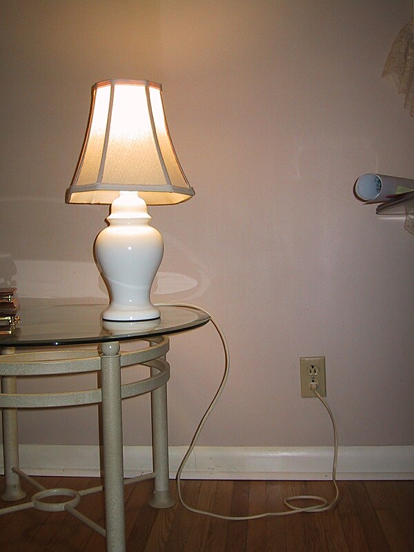 A table lamp connected to a wall socket (the mains)