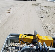 A mechanical beach cleaner with tractor attached removing unwanted beach debris Mechanical Beach Debris Removal.jpg