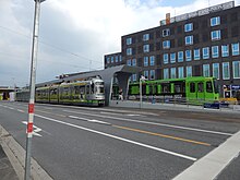 The middle high platform with a concrete roof is shown in the center.  The camera looks approximately to the northeast.  On the left in the picture a TW-2500 pair, on the right a TW 6000. The Lister Meile lane towards the right (southwest) in the foreground towards the photographer has three lanes.  Far left, the Hochstraße Berliner Allee.  At the top right the Hannover Casino with a smooth brown facade and green to blue reflecting windows.