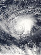 A cyclone with banding clouds wrapping cyclonically over its center; a small eye can be seen in the center of the storm