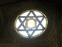Cami duvarındaki Davud'un Yıldızı desenli yuvarlık bir vitray.